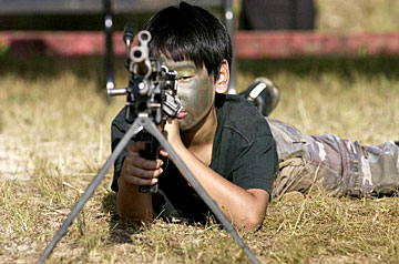 Kid pointing gun at photographer, Cindy Ellen Russell, Honolulu Star Bulletin
