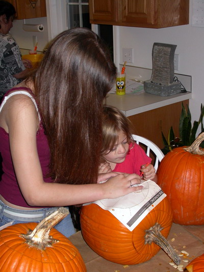 Sara and Kayla Carving Pumpkins by Josh Poulson